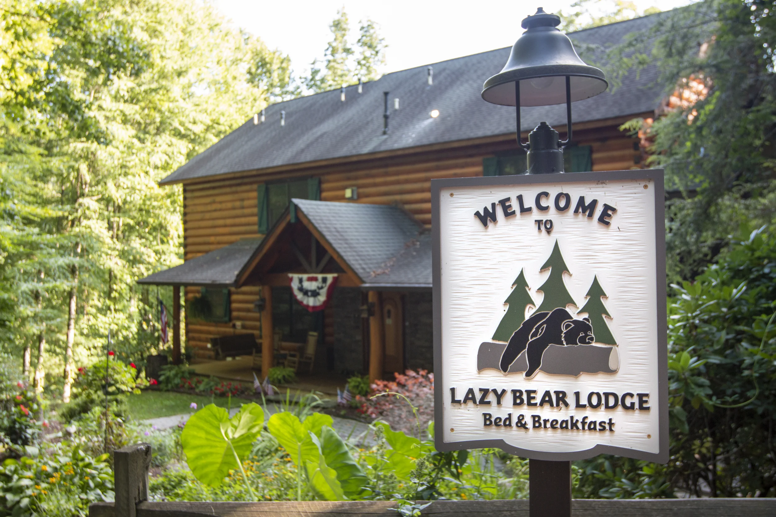 The front view of the Lazy Bear Lodge log cabin with large front porch.