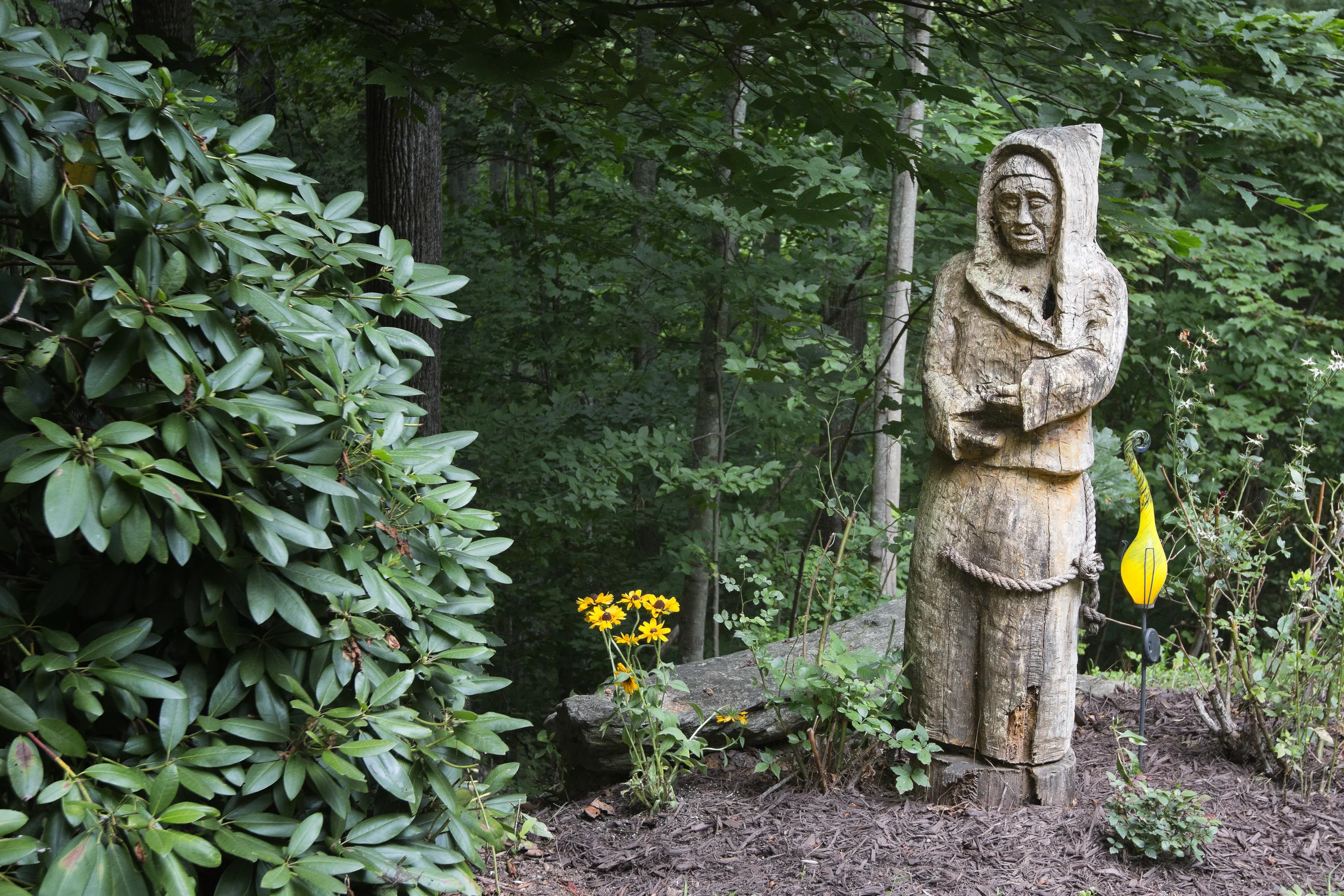 Large five foot high wood carving of a Monk in the front gardens.