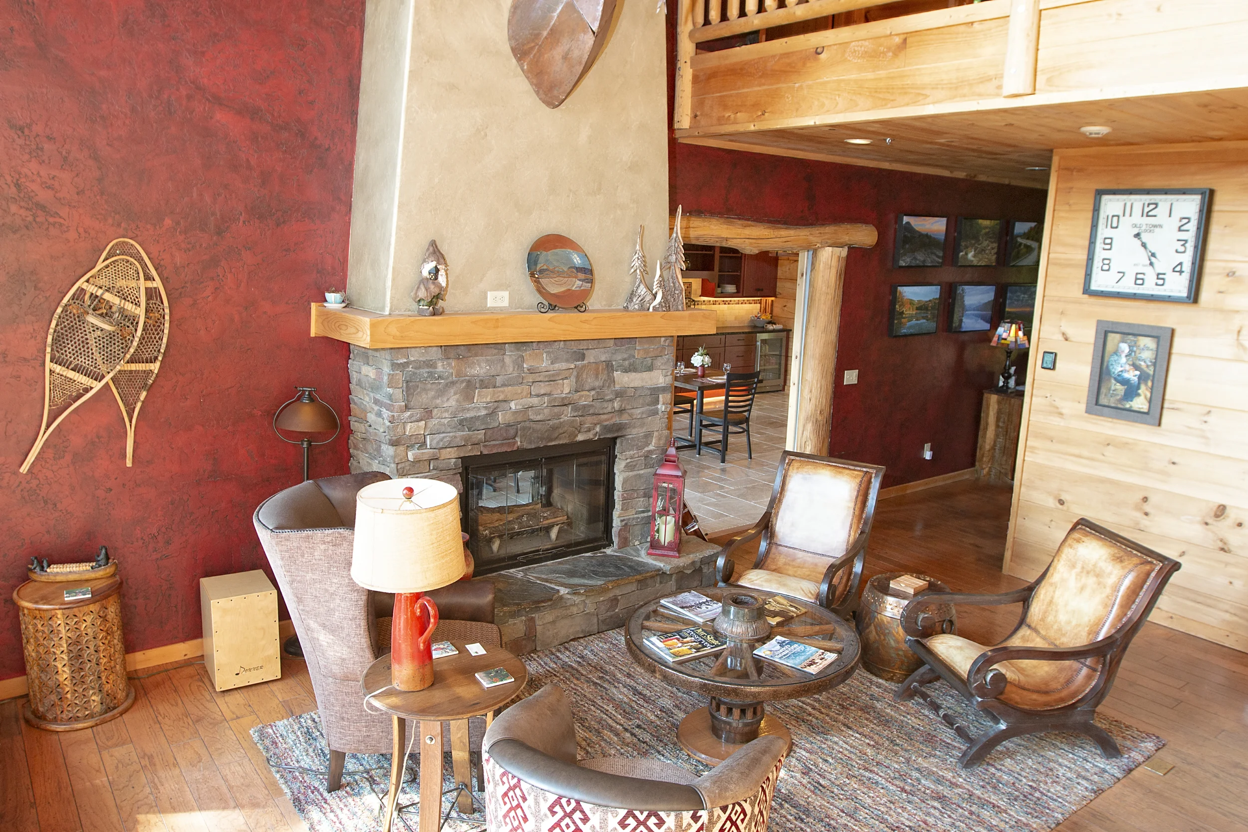 Great room features vaulted fireplace, 6 chairs, chaise lounge and two story windows with upstairs landing above.
